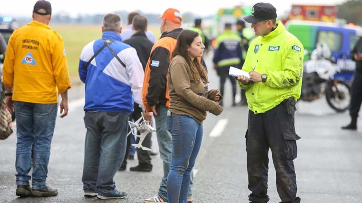 Un efectivo le toma testimonio a una de las pasajeras del micro