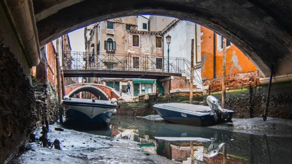 En los canales solo queda un hilo de agua por la bajante de la marea en Venecia.
