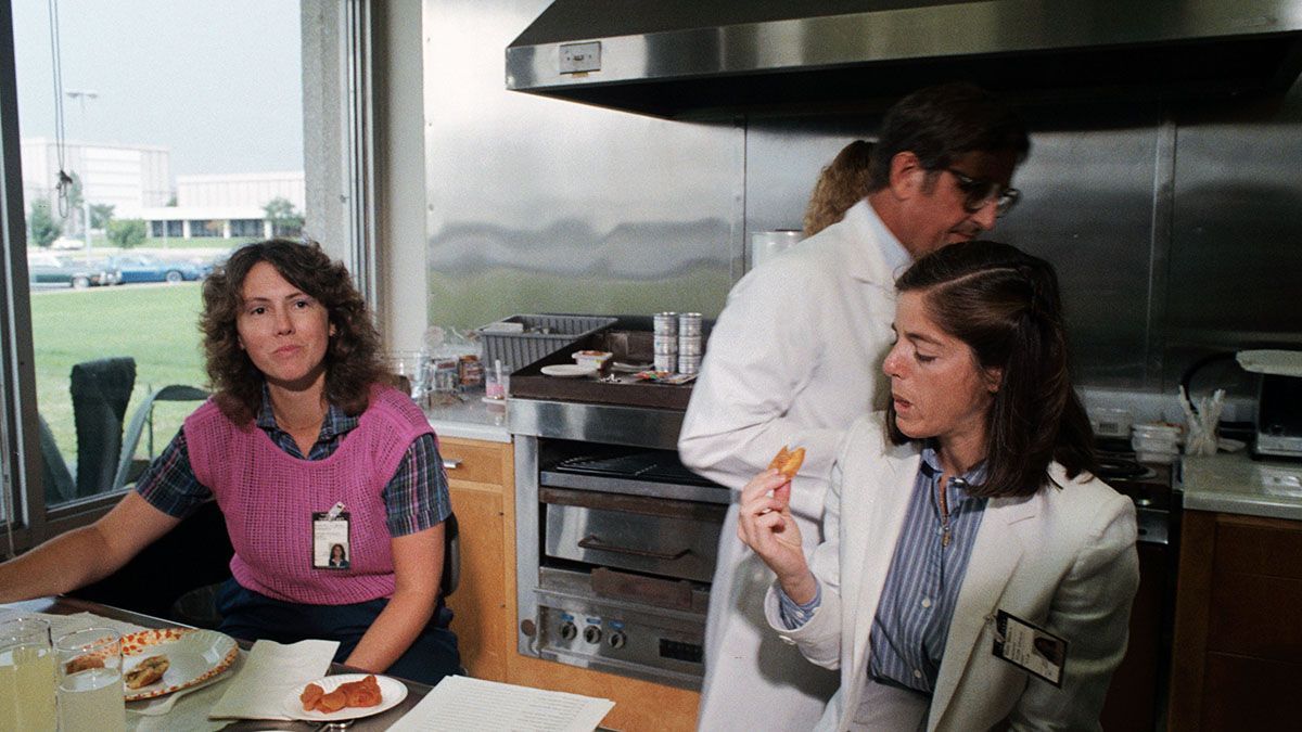 Christa McAuliffe, izquierda, parece estar decidiendo qué piensa de un pedazo de comida espacial que prueba durante una sesión de entrenamiento. Barbara R. Morgan, su reemplazante, prueba un albaricoque. 10 de septiembre de 1985. Crédito de la foto: Nasa.