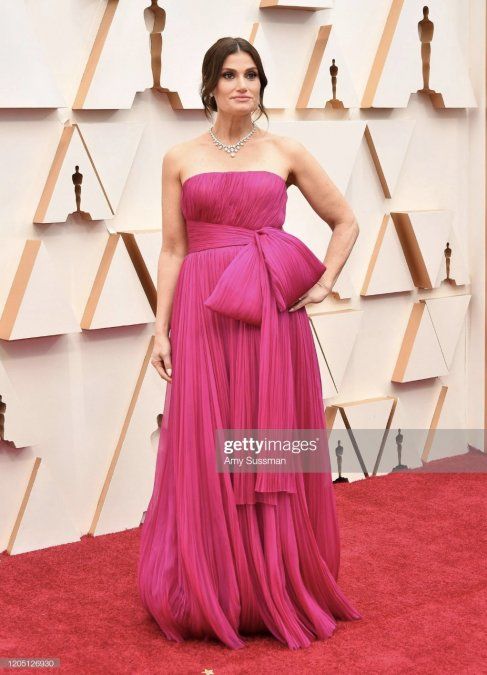 Idina Menzel en un vestido rosa con un gran lazo en el costado.