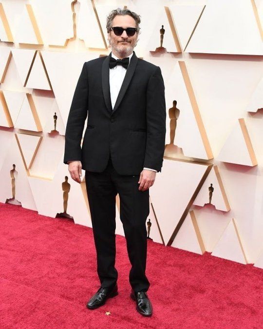 Joaquin Phoenix de negro y con el mismo traje que uso en premiaciones anteriores ya que apoya la reutilización de las prendas