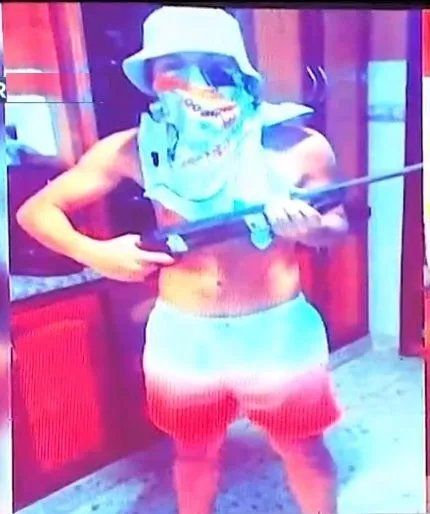 Con un fusil en la mano y el rostro cubierto