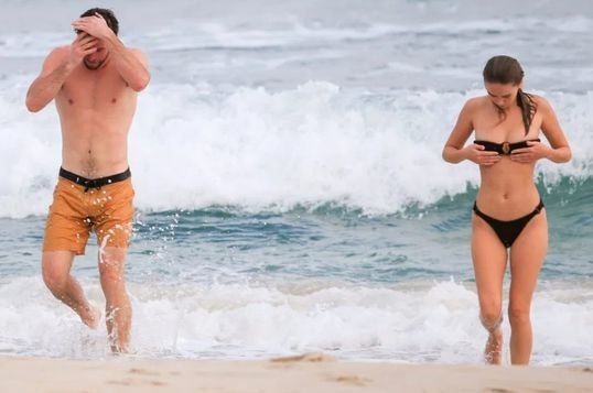 Liam Hemsworth y la modelo Gabriella Brooks en la playa