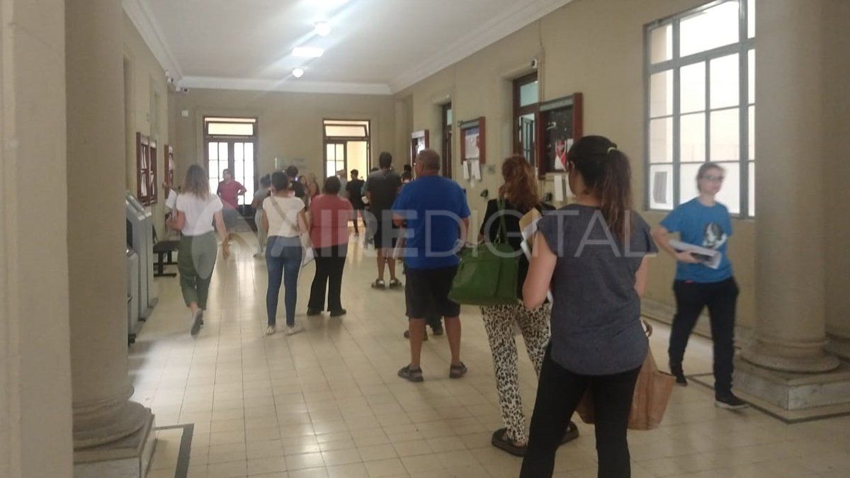 La fila para la oficina de certificaciones se realiza en el pasillo, y respetando el metro de distancia