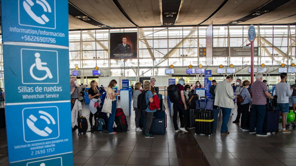 Pasajeros hacen cola en el aeropuerto internacional Arturo Merino Benítez, en Santiago de Chile, el 18 de marzo de 2020.