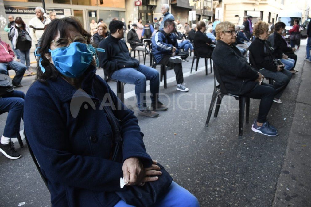 Jubilados y beneficiarios de asignaciones hacen una fila especial, con sillas, distancia y barbijos para cobrar en Rosario.