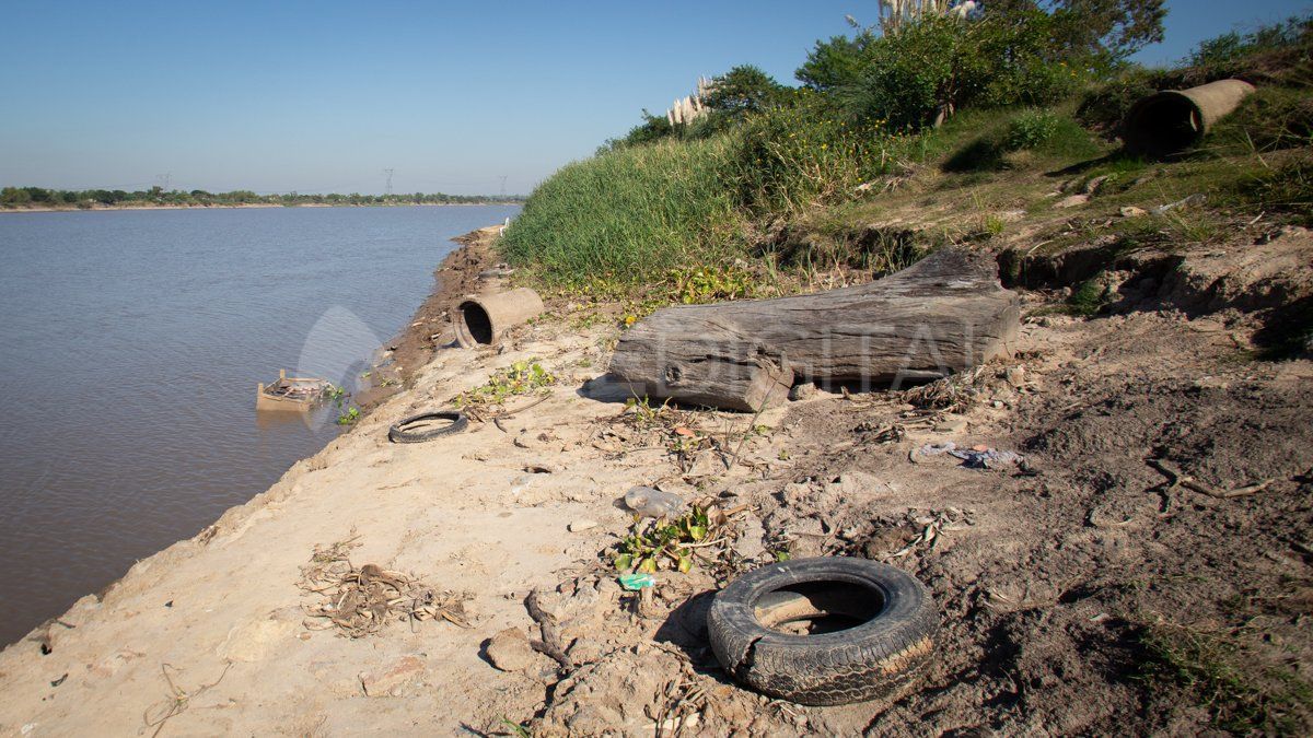 Caños de hormigón, troncos y neumáticos en la costa del Parque de la Constitución.