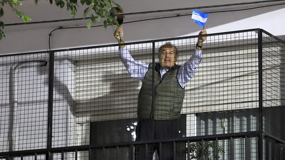 Un vecino sale con una bandera al balcón de su casa, en la ciudad de Buenos Aires.