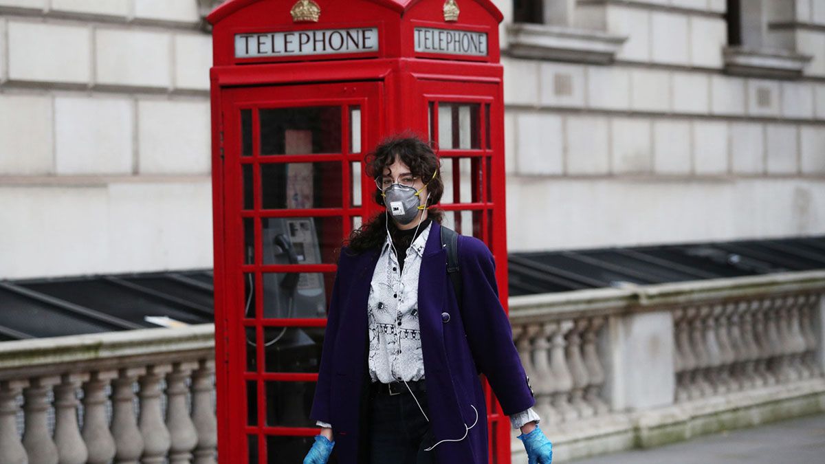 Una mujer camina con la cara cubierta por Londres, debido a la pandemia de coronavirus.