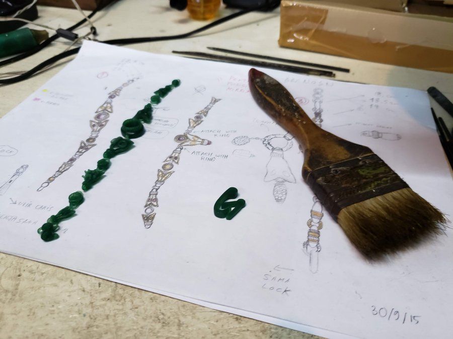 Los diseños en papel, junto al modelo de cera que se va usar para hacer este collar.