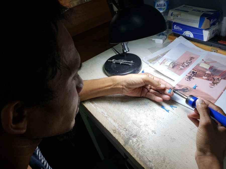 Dewa preparando uno de los moldes de cera, a partir de los diseños en papel.