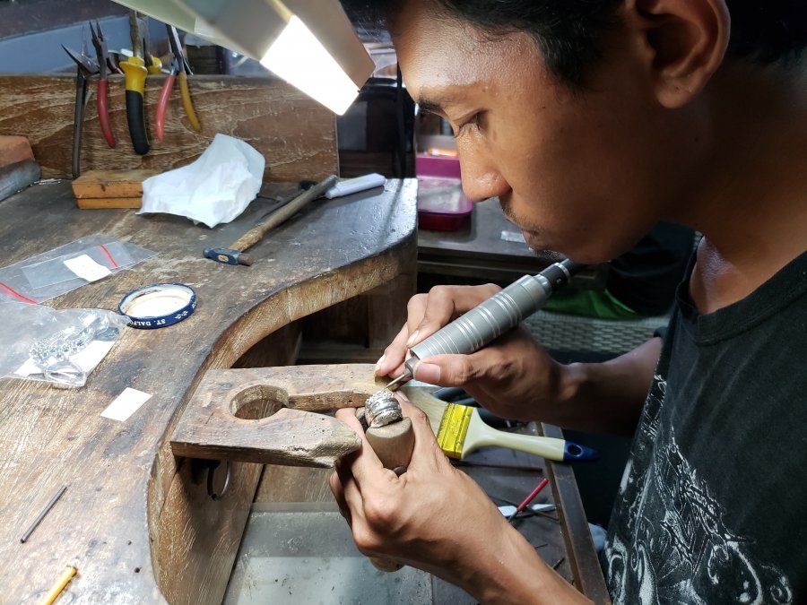 Ifam, siempre concentrado, en la precisa tarea de engarzar las piedras en los anillos y pendientes.