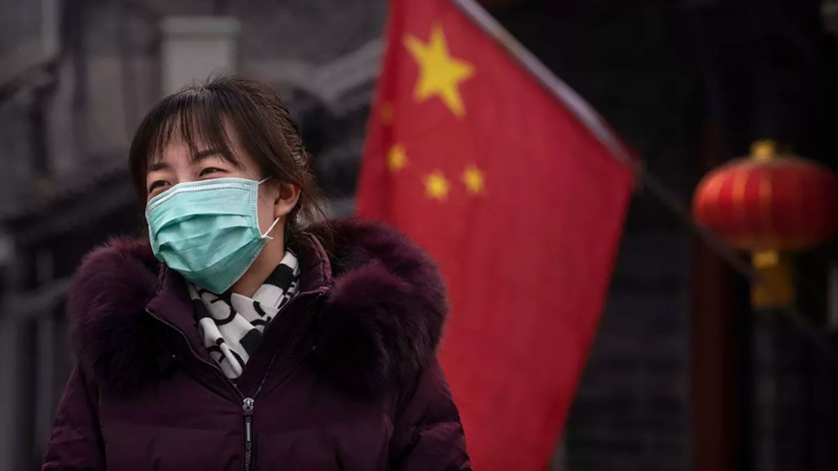 Una mujer cubre su cara con un barbijo por el brote de coronavirus en China.