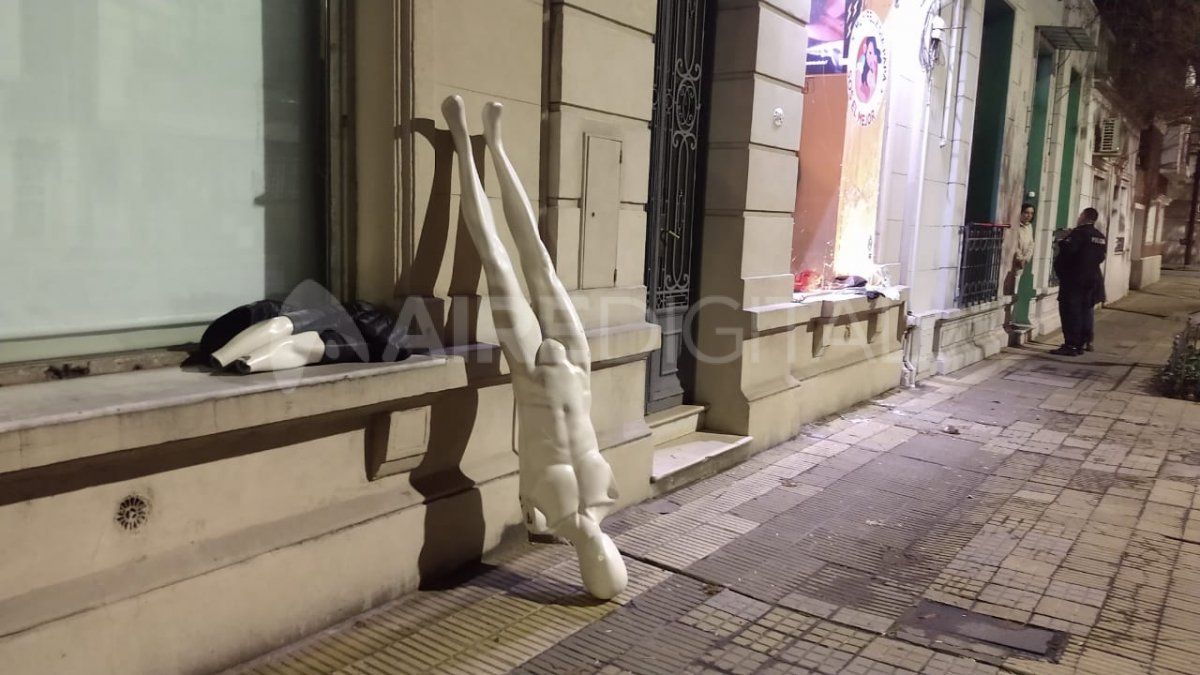 Los artículos abandonados en la vereda y los policías dialogando con la vecina luego del informe que realizó el móvil de Aire de Santa Fe