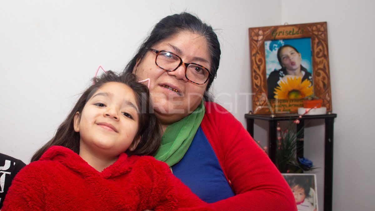 Luz Camila en la falda de su abuela Susana Montes. Detrás el retrato de la mamá de Luz, Griselda Correa, víctima de femicidio el 20 de agosto de 2013