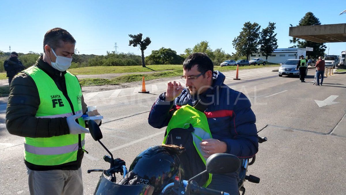 Un hombre en moto huele el hisopo para detectar si distingue la sustancia y pasar el test.