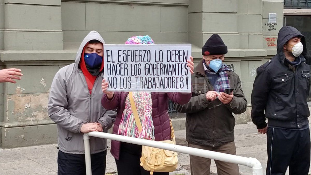 Manifestantes que trabajan en las canchas de fútbol 5 reclaman con un cartel en el Ministerio de Salud.