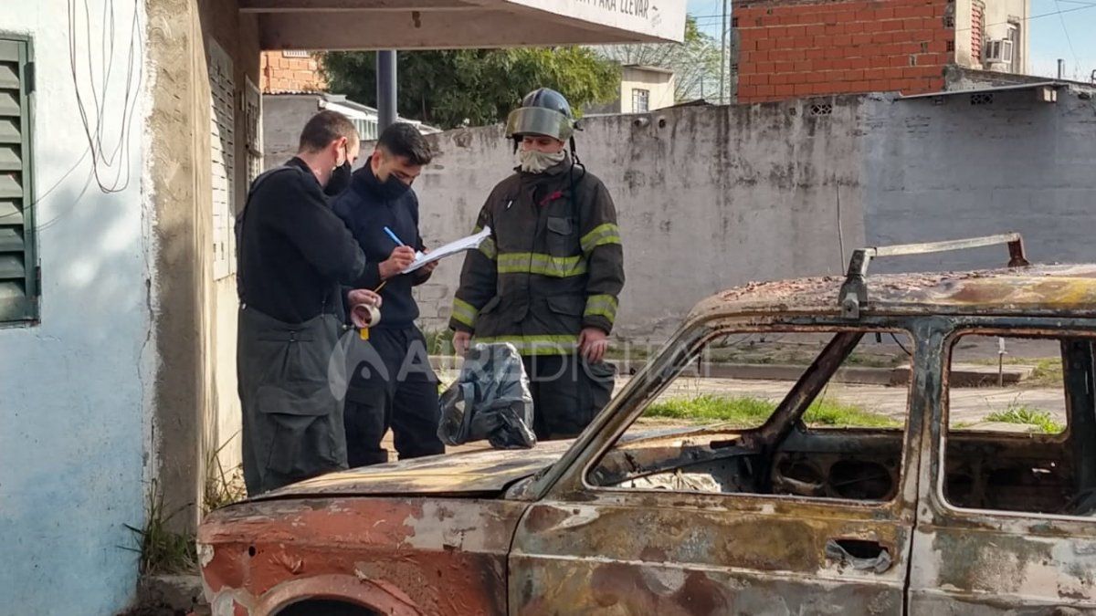 Personal de Bomberos Zapadores elabora el informe de los daños al automóvil incendiado.