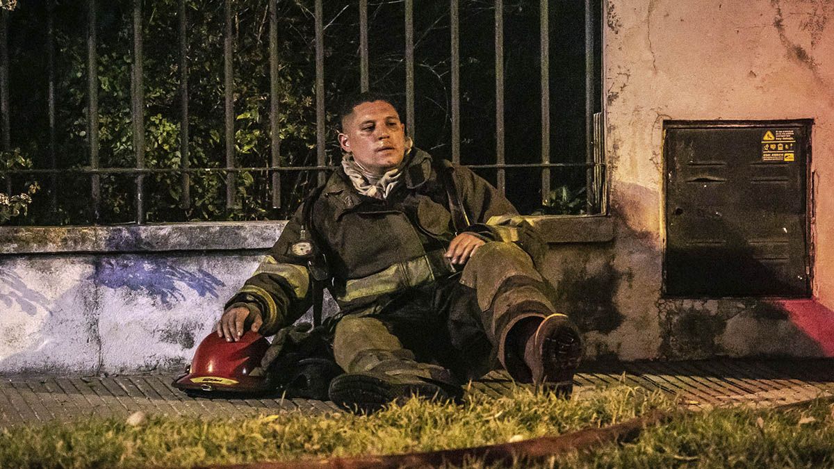 La imagen que lo dice todo. Un bombero se muestra exhausto luego de sofocar el incendio de una vivienda en Santo Tomé este miércoles. 