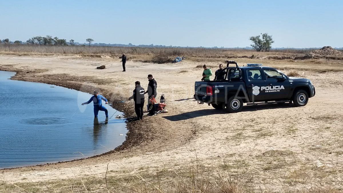 Un buzo táctico ingresa al agua para tratar de encontrar a las personas desaparecidas.