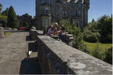 Dos amigas con un perro sobre el puente Overtoun en Dumbarton, Escocia