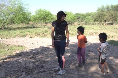 Yisela camina hasta la represa casi seca que está a unos metros de su casa, acompañada por sus primos Néstor (5) y Alejandro (6).