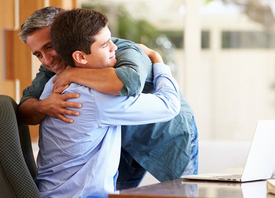 abrazo padre y adolescente