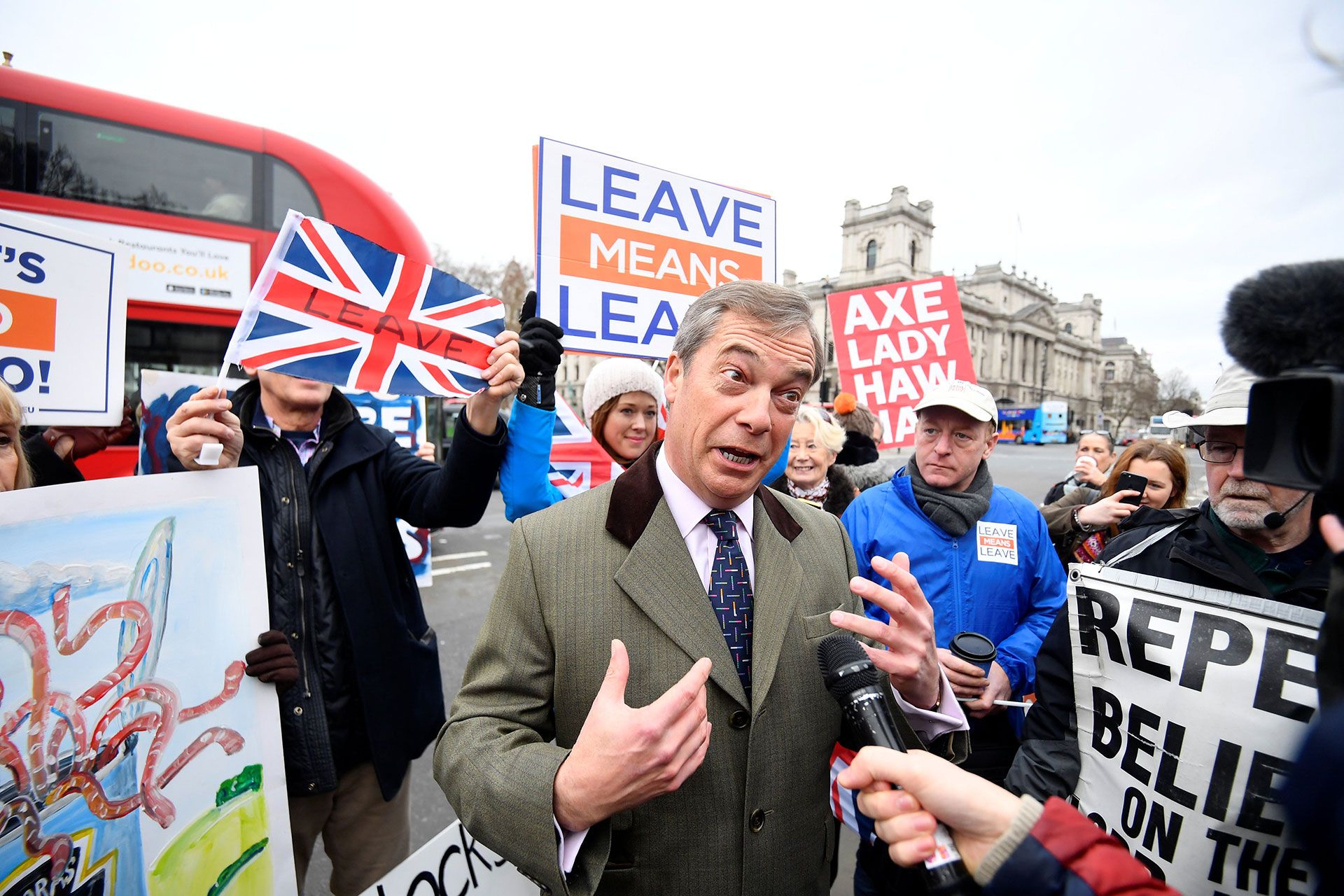 El ex lÃder del UKIP Nigel Farage habla a los medios de comunicación mientras los manifestantes a favor y en contra del proyecto de ley se manifiestan frente a la sede del Parlamento en Londres, Gran Bretaña, el 15 de enero de 2019. (Reuters)