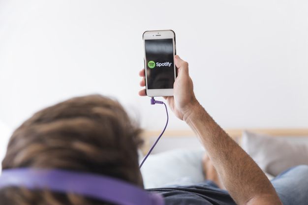 Hombre joven sosteniendo smartphone con app de spotify