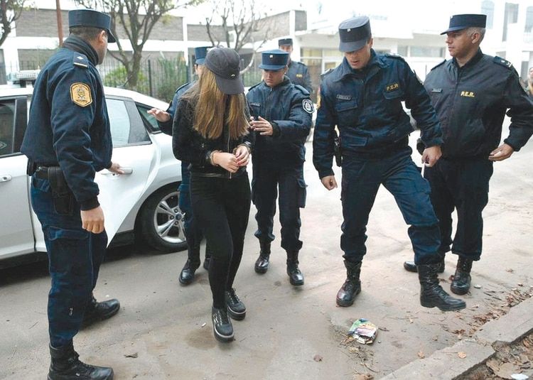 La joven en uno de los tantos traslados a la cÃ¡rcel, intentando ocultar su rostro.