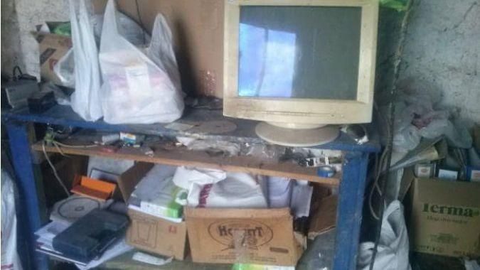 Un monitor, CD's, cajas abiertas, bolsas de supermercado y carpetas de oficina.