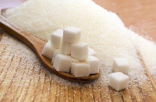 Azucarillos sobre una cuchara de madera: limitar el consumo de azúcar