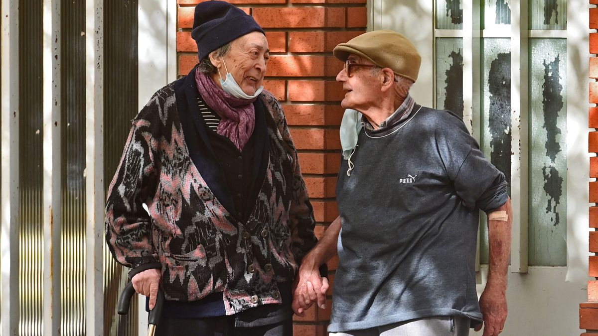 La imagen de los abuelos sentados y tomados amorosamente de la mano y arropados por causa del frío