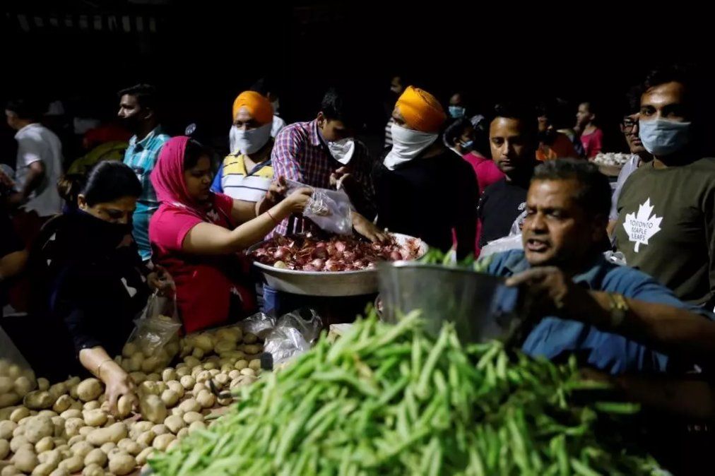 Gente comprando verduras en un mercado después de que el primer ministro de India, Narendra Modi, pidiera un cierre nacional para limitar la propagación del coronavirus. Nueva Delhi, India. 24 de marzo de 2020. © Anushree Fadnavis / Reuters