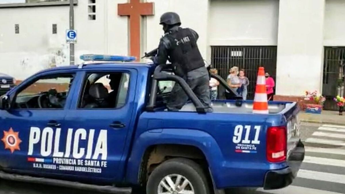 Uno de los policías que custodiaba, con un arma de grueso calibre, que el ataúd llegara a su destino.