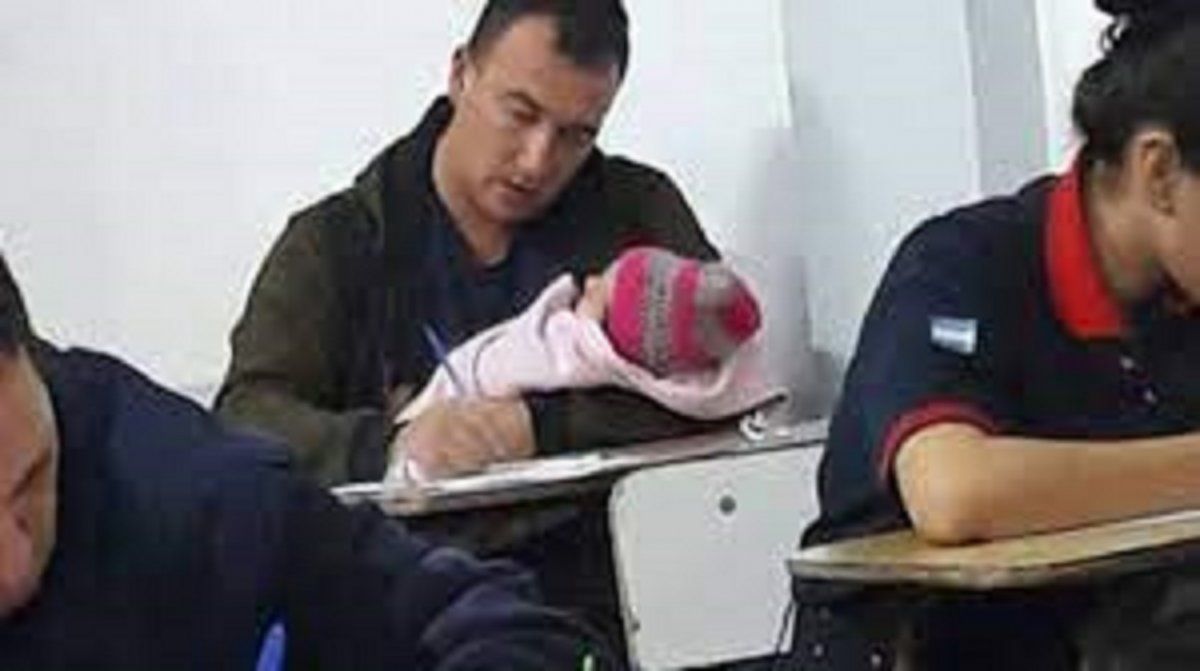 Un bombero rindió un examen con su beba en brazos.