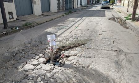 Barrio Mariano Comas: con birome sobre una hoja de cuaderno aplicada en una cruz de madera, un vecino señalizó un cráter. Barrio Mariano Comas: con birome sobre una hoja de cuaderno aplicada en una cruz de madera, un vecino señalizó un cráter.