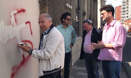Como símbolo contra la discriminación, funcionarios e integrantes de la comunidad judía cubrieron la esvástica pintada en el frente de la sinagoga. Como símbolo contra la discriminación, funcionarios e integrantes de la comunidad judía cubrieron la esvástica pintada en el frente de la sinagoga.