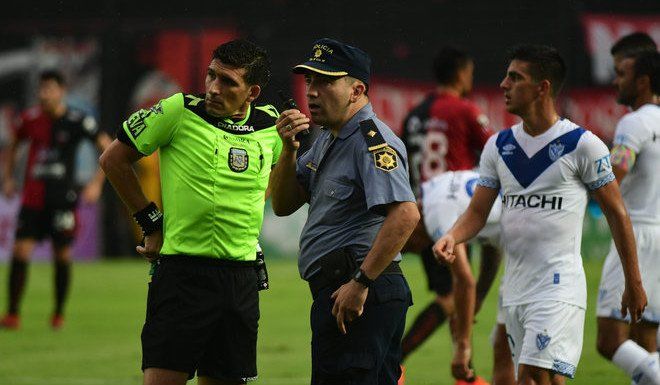 Andrés Merlos hablando con el jefe del operativo pidiendo seguridad para continuar el evento. Como siguieron cayendo proyectiles explosivos, Merlos suspendió el partido por