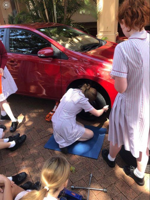 Una de las alumnas en plena tarea de cambio de un neumático
