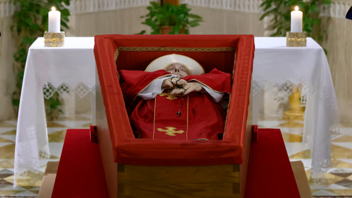 Francisco yace en su féretro, con túnica roja y un rosario en sus manos. Francisco yace en su féretro, con túnica roja y un rosario en sus manos.
