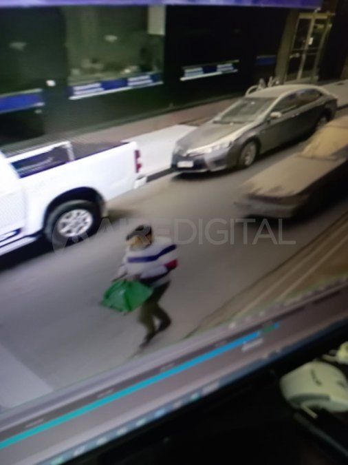 El ladrón llevándose la computadora.