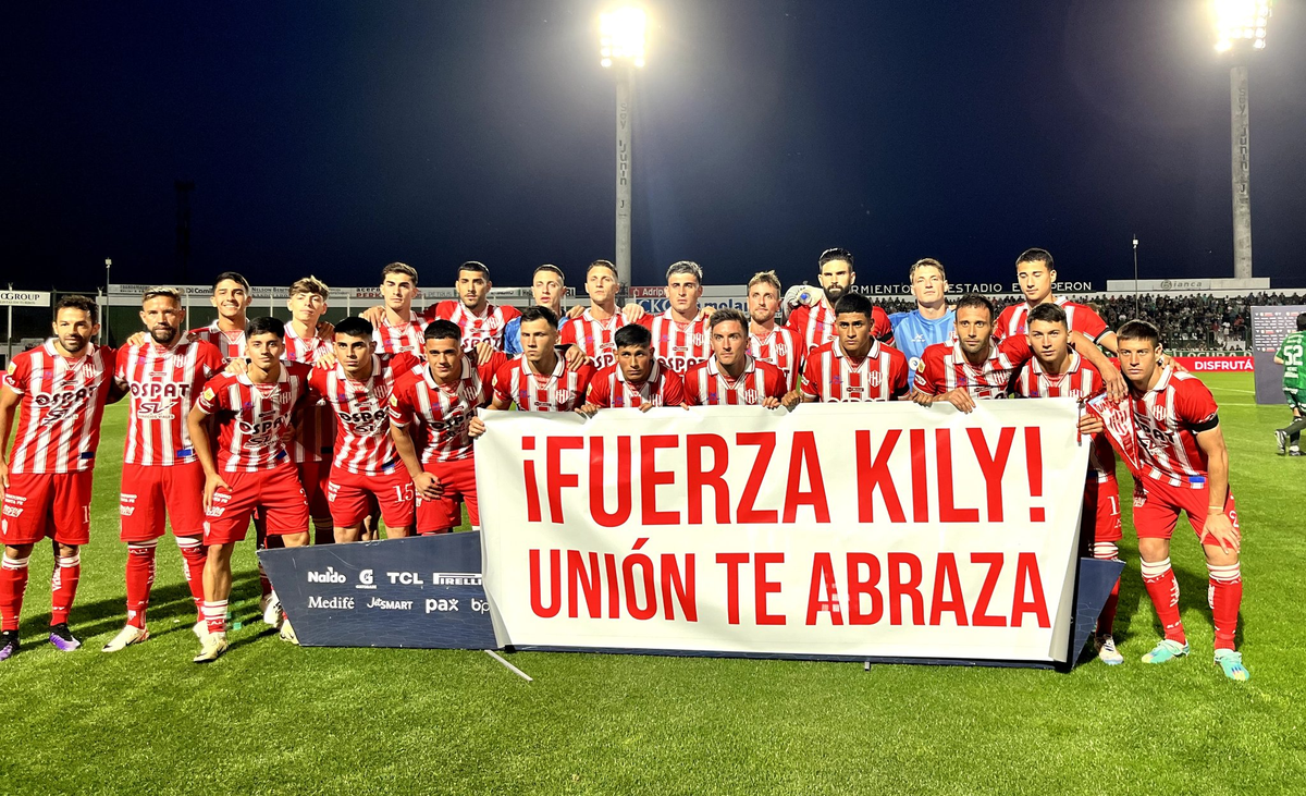 Los futbolistas del conjunto tatengue posaron en la salida al campo de juego con una bandera que decía "¡Fuerza Kily! Unión te abraza". Los futbolistas del conjunto tatengue posaron en la salida al campo de juego con una bandera que decía "¡Fuerza Kily! Unión te abraza".
