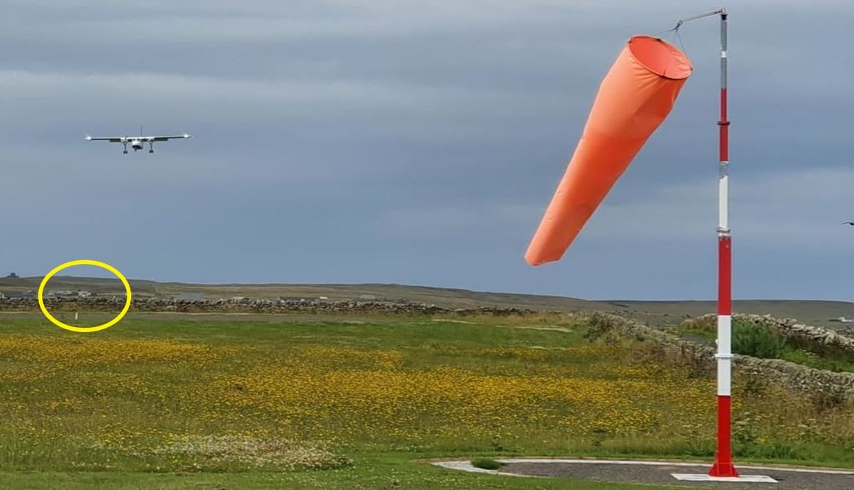 Esta foto, tomada desde la pista de Papa Westary, muestra al avión en su aproximación final para aterrizar en la misma y, en el círculo, alcanza a apreciarse el aeródromo de Westray, desde donde despegó.