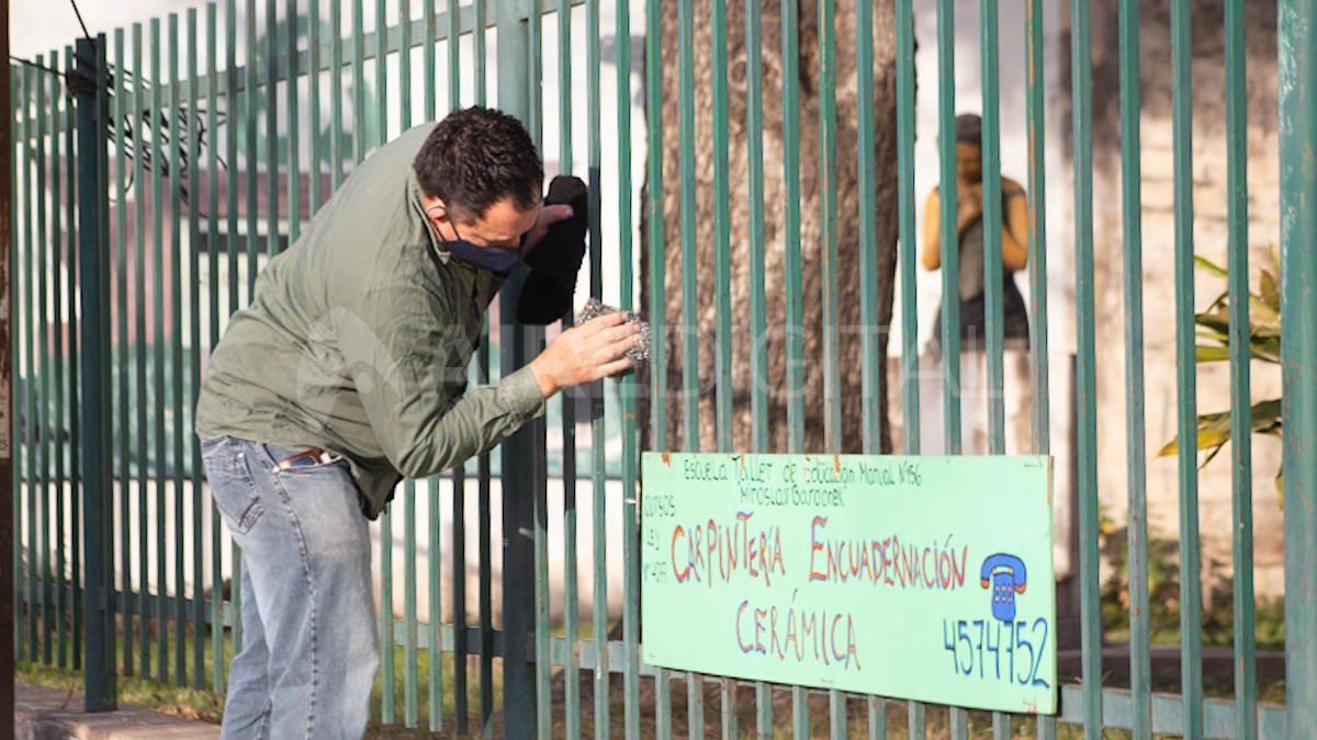 Pintan las rejas del frente de la Escuela Falucho en el marco de las tareas de mantenimiento.