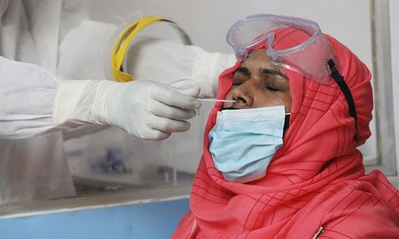 Un médico realiza un hisopado para detectar coronavirus en la India.