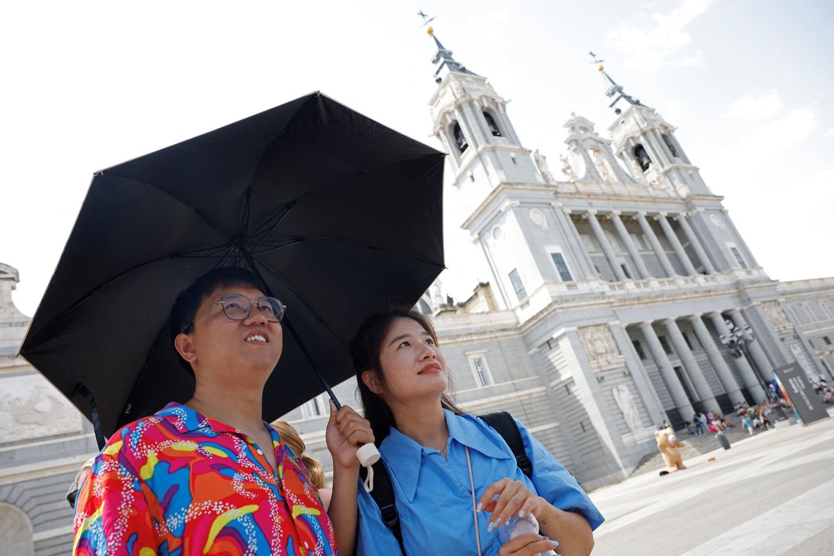 Los turistas hacen cola para entrar al museo del Palacio Real en medio de una ola de calor en Madrid