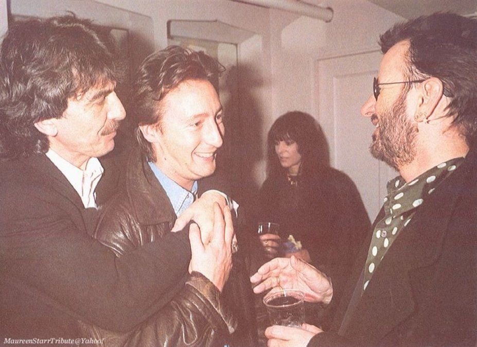 Harrison abraza a Julian Lennon, el hijo mayor de John, mientras conversan con Ringo Starr