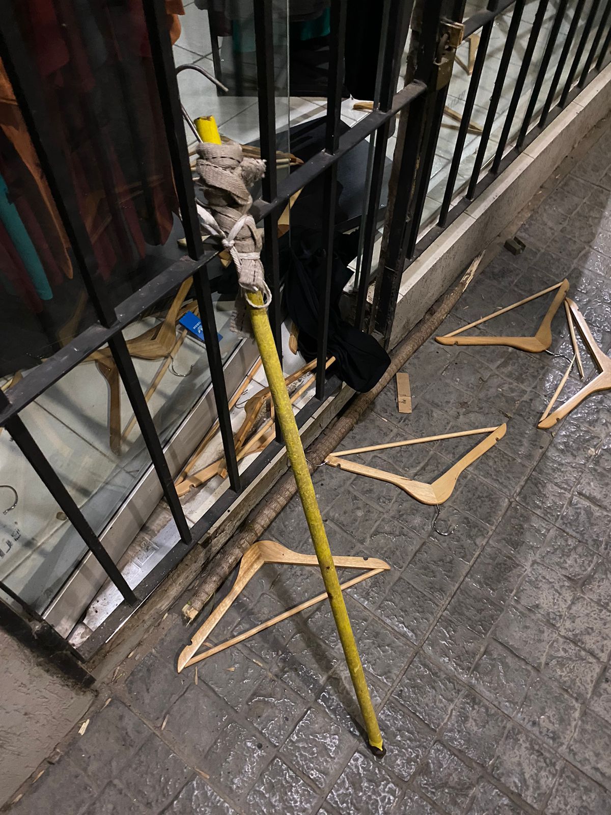 Los delincuentes rompen la vidriera y, con un palo, extraen indumentaria. Los delincuentes rompen la vidriera y, con un palo, extraen indumentaria.