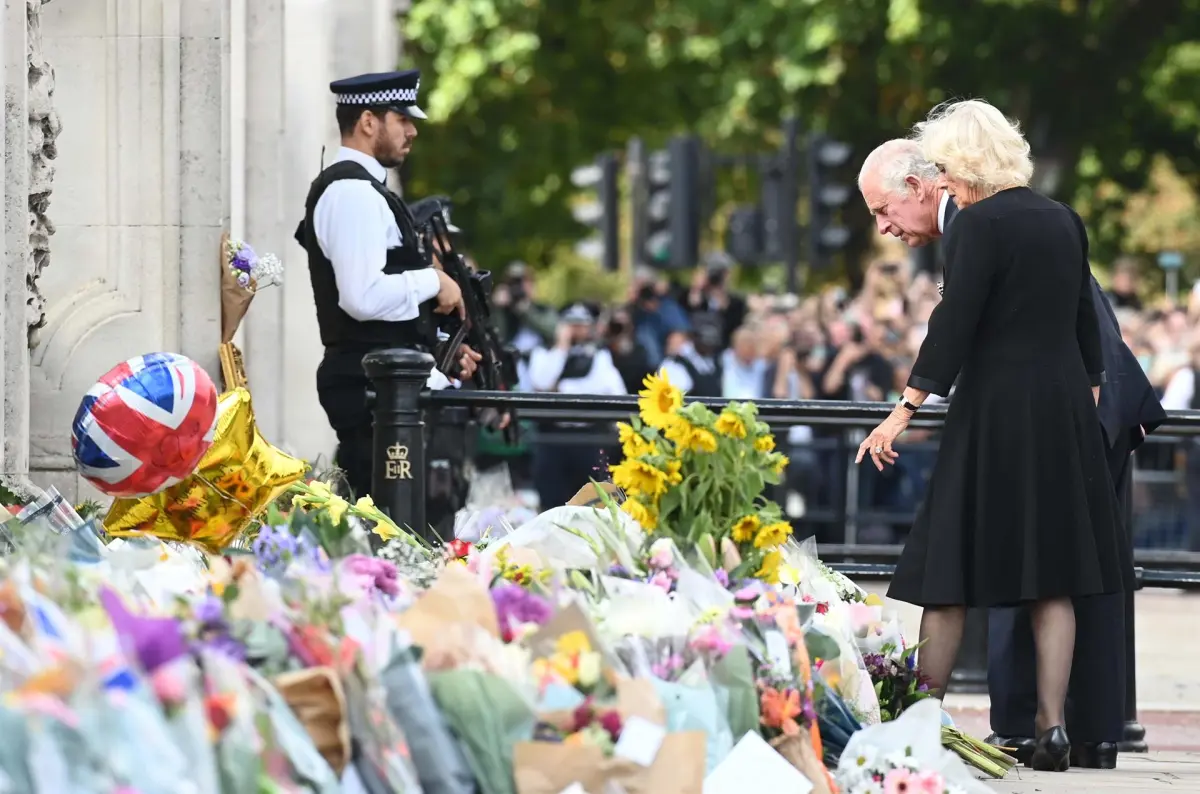 El rey Carlos III de Gran Bretaña y Camilla, la reina consorte, observan los tributos florales a su llegada al Palacio de Buckingham | Foto; Archivo - EFE Credit: EFE